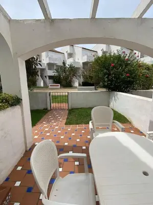 a patio with a white table and chairs on a patio at Cozy Apart. Costa Sancti Petri by Chiclana Dreams in Novo Sancti Petri