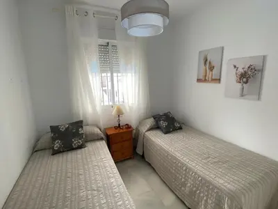 a bedroom with two beds and a window at Apartamento Costa de Sancti Petri by Chiclana Dreams in Novo Sancti Petri