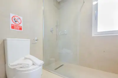 a bathroom with a glass shower and a toilet at Moon Villa Conil con piscina in Conil de la Frontera