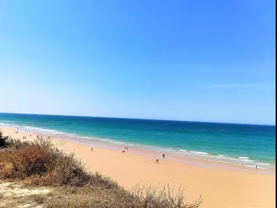 a group of people on a beach near the ocean at Moon Villa Conil con piscina in Conil de la Frontera