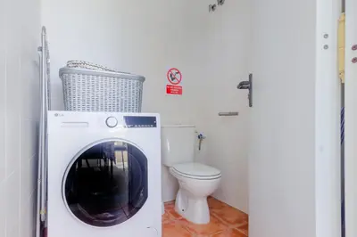 a washing machine in a bathroom with a toilet at Moon Villa Conil con piscina in Conil de la Frontera