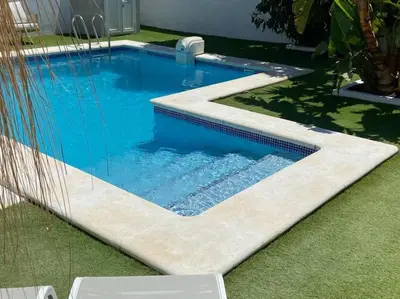 a swimming pool with blue water in a yard at Moon Villa Conil con piscina in Conil de la Frontera