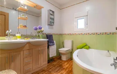a bathroom with a tub and a toilet and a sink at Lovely Home In Chiclana De La Fronter in Chiclana de la Frontera