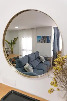 a living room with a blue couch in a mirror at Calvario 53 by 7Escalones in Rota