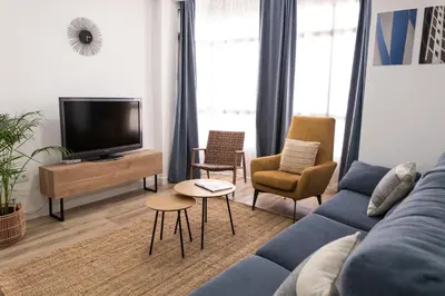 a living room with a blue couch and chairs at Calvario 53 by 7Escalones in Rota