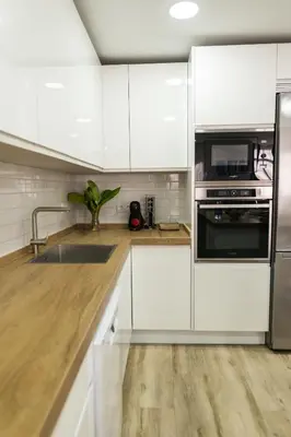 a kitchen with white cabinets and stainless steel appliances at Calvario 53 by 7Escalones in Rota