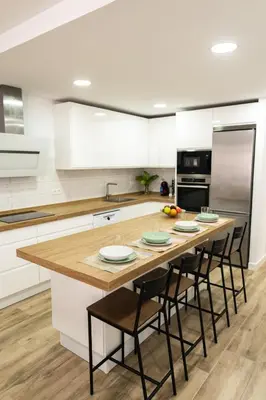 a kitchen with a large wooden table with chairs at Calvario 53 by 7Escalones in Rota
