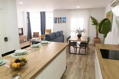 a kitchen and living room with a table with a bowl of fruit at Calvario 53 by 7Escalones in Rota