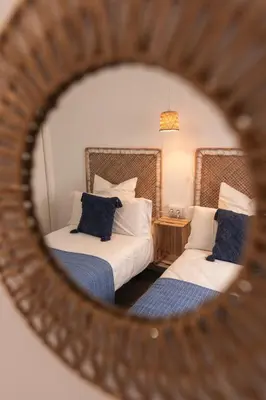 a mirror reflection of a bedroom with two beds at Calvario 53 by 7Escalones in Rota