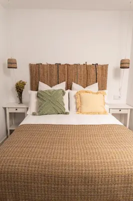 a bedroom with a large bed with pillows at Calvario 53 by 7Escalones in Rota