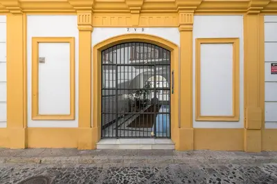 a yellow and white building with a barred window at Vegaluz in Jerez de la Frontera
