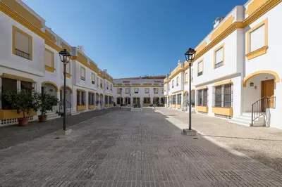 an empty street with white and yellow buildings at Vegaluz in Jerez de la Frontera