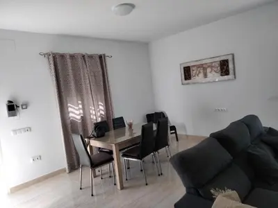 a living room with a table and chairs and a couch at Casa Caleta in Conil de la Frontera