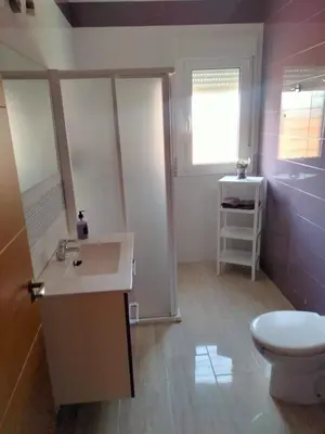 a bathroom with a sink and a toilet and a window at Casa Caleta in Conil de la Frontera