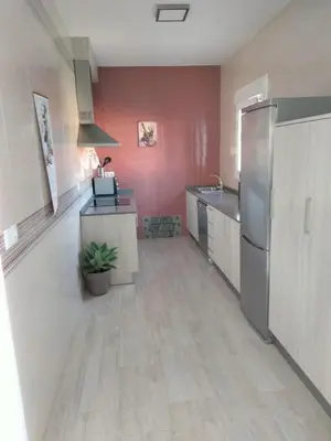 a kitchen with a stainless steel refrigerator and a counter at Casa Caleta in Conil de la Frontera