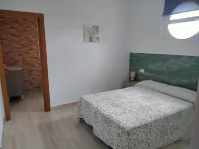 a small bedroom with a bed and a window at Casa Caleta in Conil de la Frontera