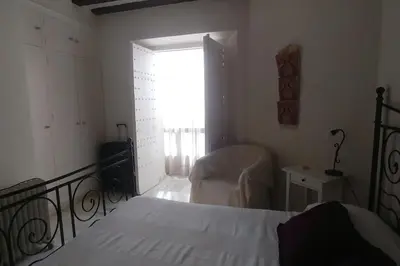 a bedroom with a bed and a chair and a window at Las 4 Torres by Gades Gestión in Cádiz