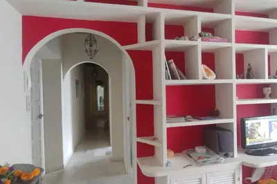 a living room with red walls and white shelves at Las 4 Torres by Gades Gestión in Cádiz