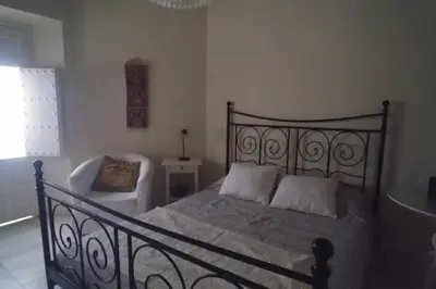 a bedroom with a large bed and a chair at Las 4 Torres by Gades Gestión in Cádiz