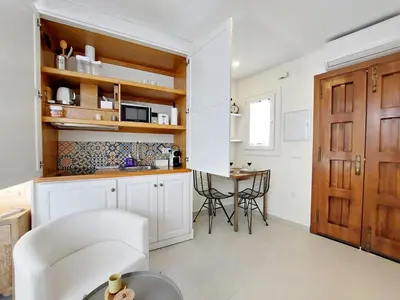a kitchen with white cabinets and a table with chairs at Casita de la Suerte in Medina Sidonia