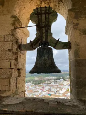 a view through a window of a bell in a tower at Casita de la Suerte in Medina Sidonia
