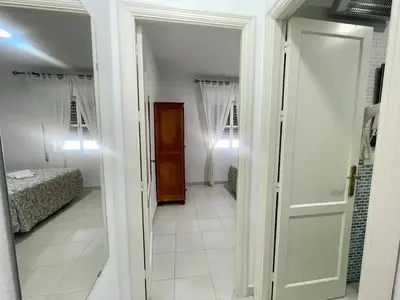 a hallway with a room with two beds and a door at Pescadores del Sur in Chiclana de la Frontera