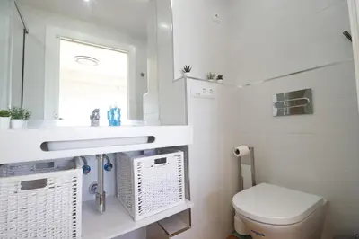 a bathroom with a toilet and a sink and a window at Summerlandrota Cordoba8 in Rota