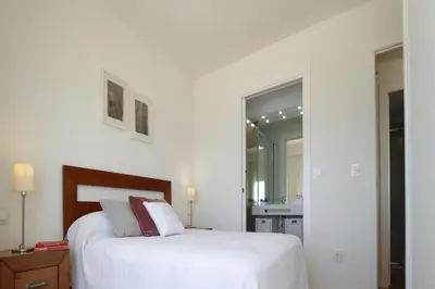 a white bedroom with a bed and a mirror at Summerlandrota Cordoba8 in Rota