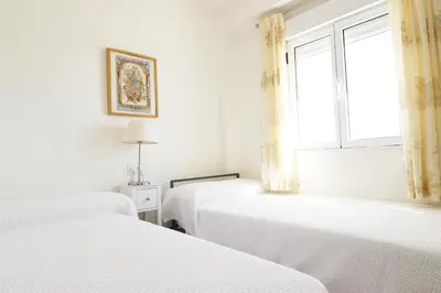 two beds in a white room with a window at Summerlandrota Cordoba8 in Rota