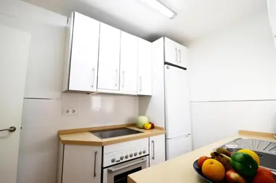 a kitchen with white cabinets and a bowl of fruit at Summerlandrota Cordoba8 in Rota