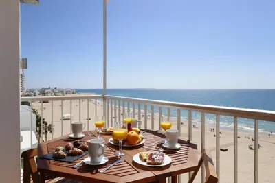 a table on a balcony with a view of the beach at Summerlandrota Cordoba8 in Rota