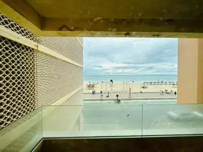 a bathroom with a tub with a view of the beach at Amanecer frente al Mar Grupo AC Gestion in Cádiz