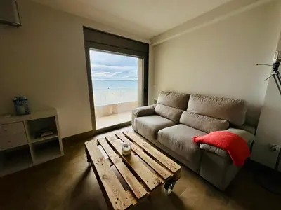 a living room with a couch and a table and a window at Amanecer frente al Mar Grupo AC Gestion in Cádiz