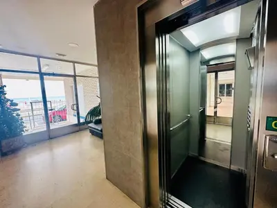 an elevator in an office building with a glass door at Amanecer frente al Mar Grupo AC Gestion in Cádiz