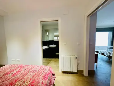 a bedroom with a bed and a bathroom with a sink at Amanecer frente al Mar Grupo AC Gestion in Cádiz
