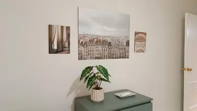a room with a table with a plant and three paintings at Sherryflat Aina Parking in Jerez de la Frontera
