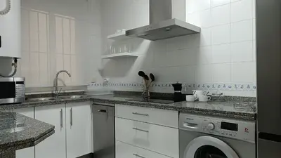 a white kitchen with a washing machine in it at Sherryflat Aina Parking in Jerez de la Frontera