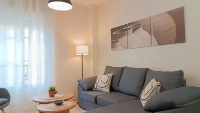 a living room with a blue couch and a table at Sherryflat Aina Parking in Jerez de la Frontera