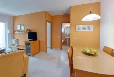 a living room with a table with a bowl of fruit on it at Piso a dos calles de la playa in El Puerto de Santa María