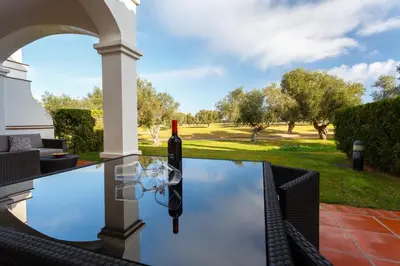 a pool with a wine bottle and a wine glass on top at Arcos Gardens Sol Rent Golf in Arcos de la Frontera