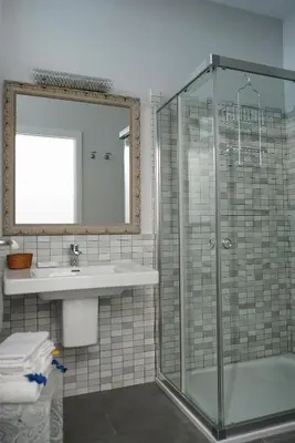 a bathroom with a glass shower and a sink at Casa Limon in Sanlúcar de Barrameda