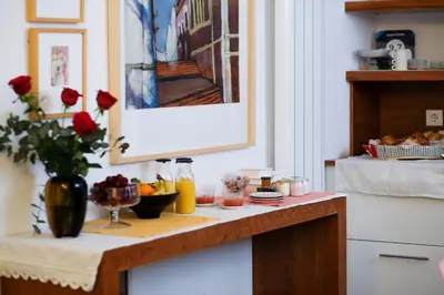 a kitchen counter with a table with food and flowers at Casa Limon in Sanlúcar de Barrameda