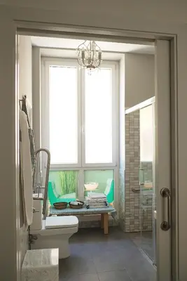 a bathroom with a window and a sink and a toilet at Casa Limon in Sanlúcar de Barrameda