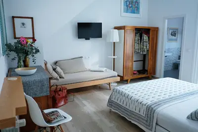 a bedroom with a bed and a table and a chair at Casa Limon in Sanlúcar de Barrameda