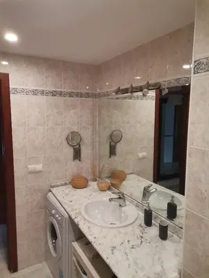 a bathroom with a sink and a washing machine at Duplex con garaje privado in Cádiz