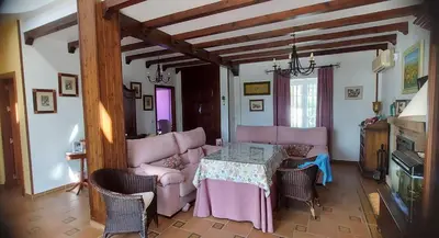 a living room with a table and pink furniture at Casa Victoria in Arcos de la Frontera