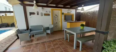 a patio with a table and chairs and a tv at Casa Victoria in Arcos de la Frontera