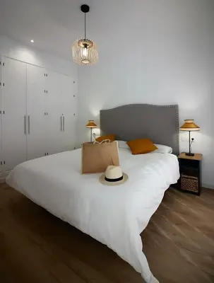a bedroom with a large white bed with a hat on it at Villa Tres Mares in Novo Sancti Petri