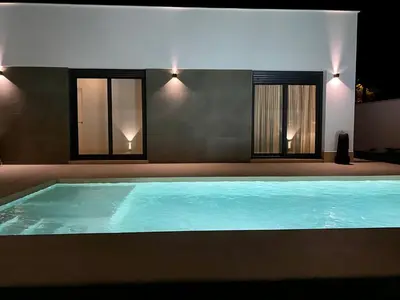 a large swimming pool in a room with two windows at Villa Tres Mares in Novo Sancti Petri