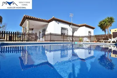 a swimming pool in front of a house at Chalet con Piscina privada en Conil in Conil de la Frontera